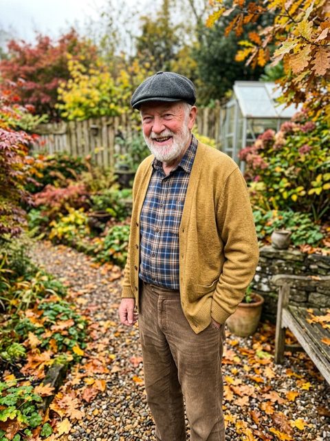 Uploaded photo: A garden snapshot of a grandfather. Same beard and grin, now in the pointed cap and striped stockings.
